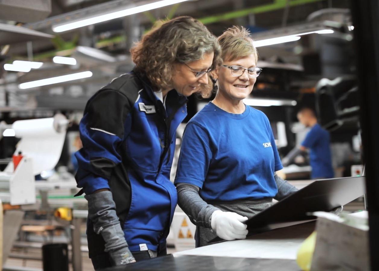 Two SCHOTT quality engineers inspect a SCHOTT CERAN® glass-ceramic cooktop panel
