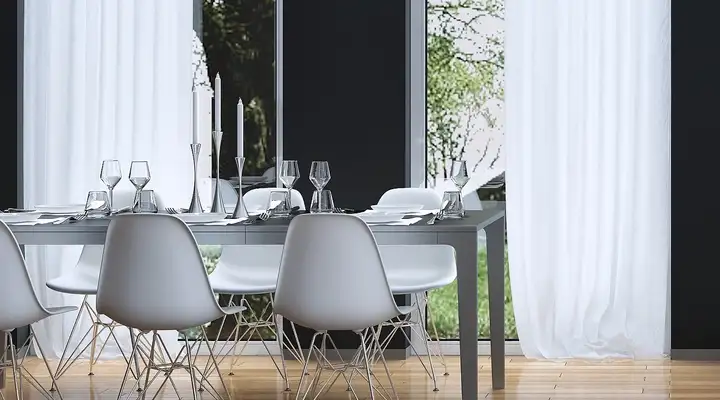 White modern kitchen with black appliances and white table and chairs