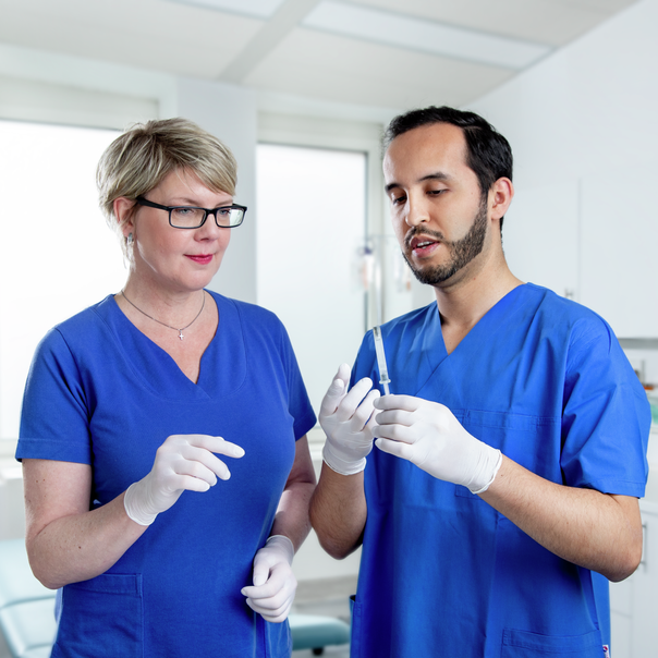 Two medical professionals examine SCHOTT TOPPAC® freeze prefillable polymer syringes for deep-cold applications.