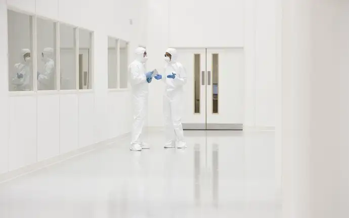  Two scientists in protective clothing inside a cleanroom