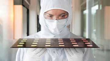 Scientist inspecting glass-based semiconductor packaging