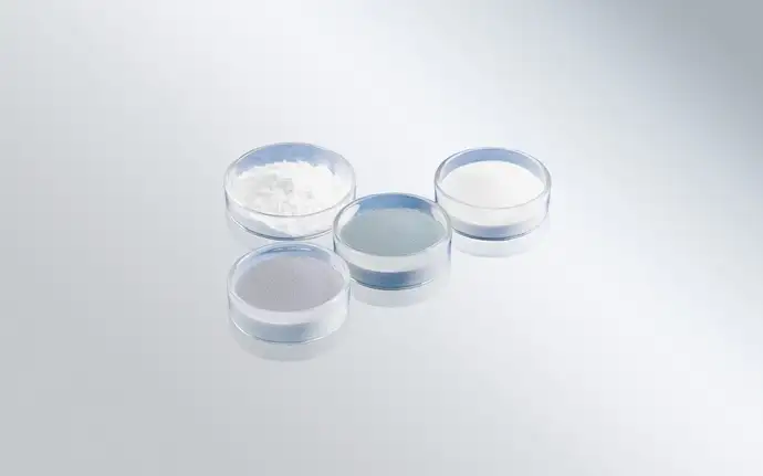 Four glass dishes full of different types of glass powder