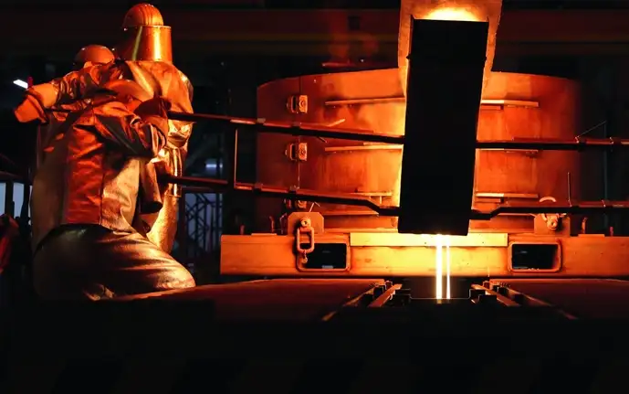 Factory workers pouring molten glass into a mold