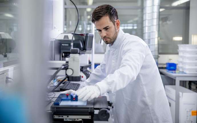 Male lab worker looking at syringe