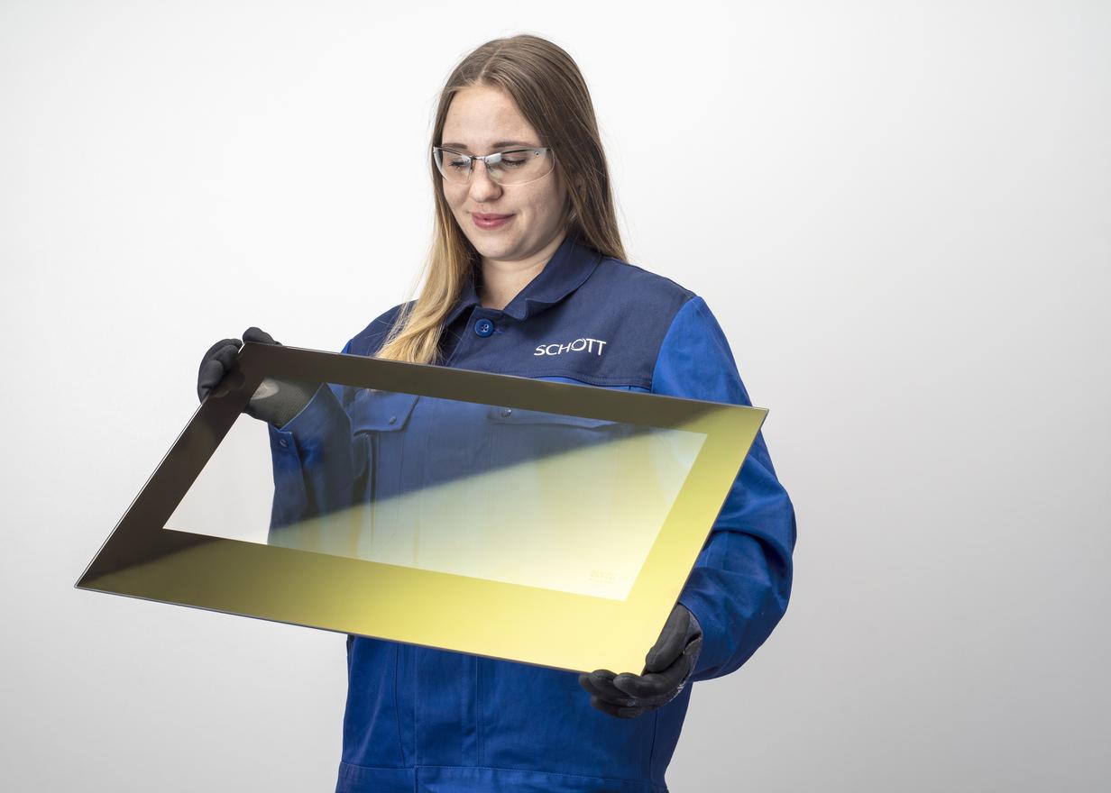 Female SCHOTT engineer inspecting a panel of ROBAX® IR SuperMax glass-ceramic	