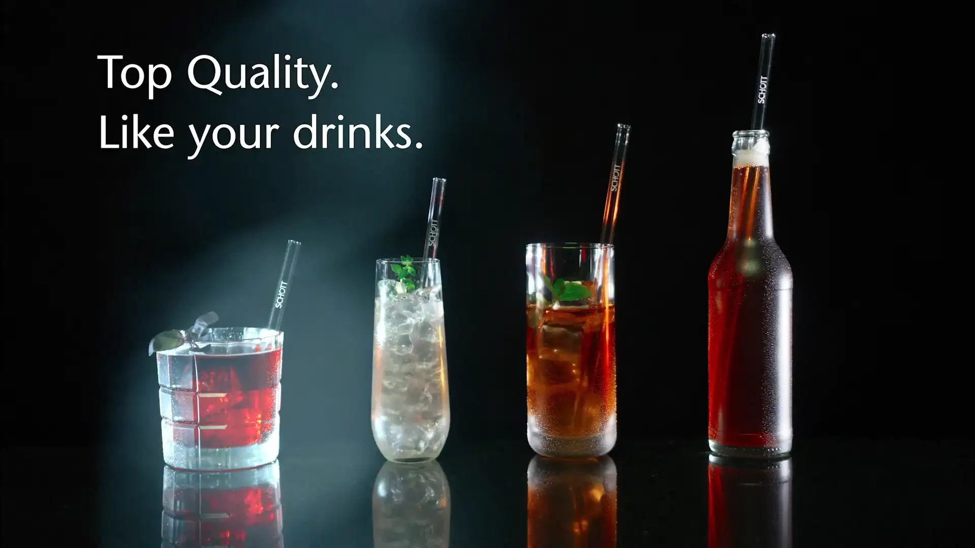 Line of drinks glasses and a glass bottle with glass straws	