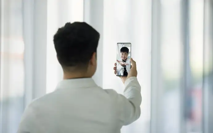 用户手持配备肖特盖板玻璃的手机