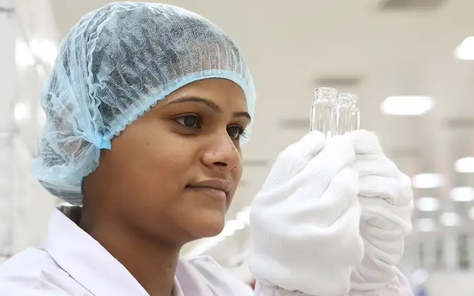 Mujer inspeccionando dos viales de vidrio