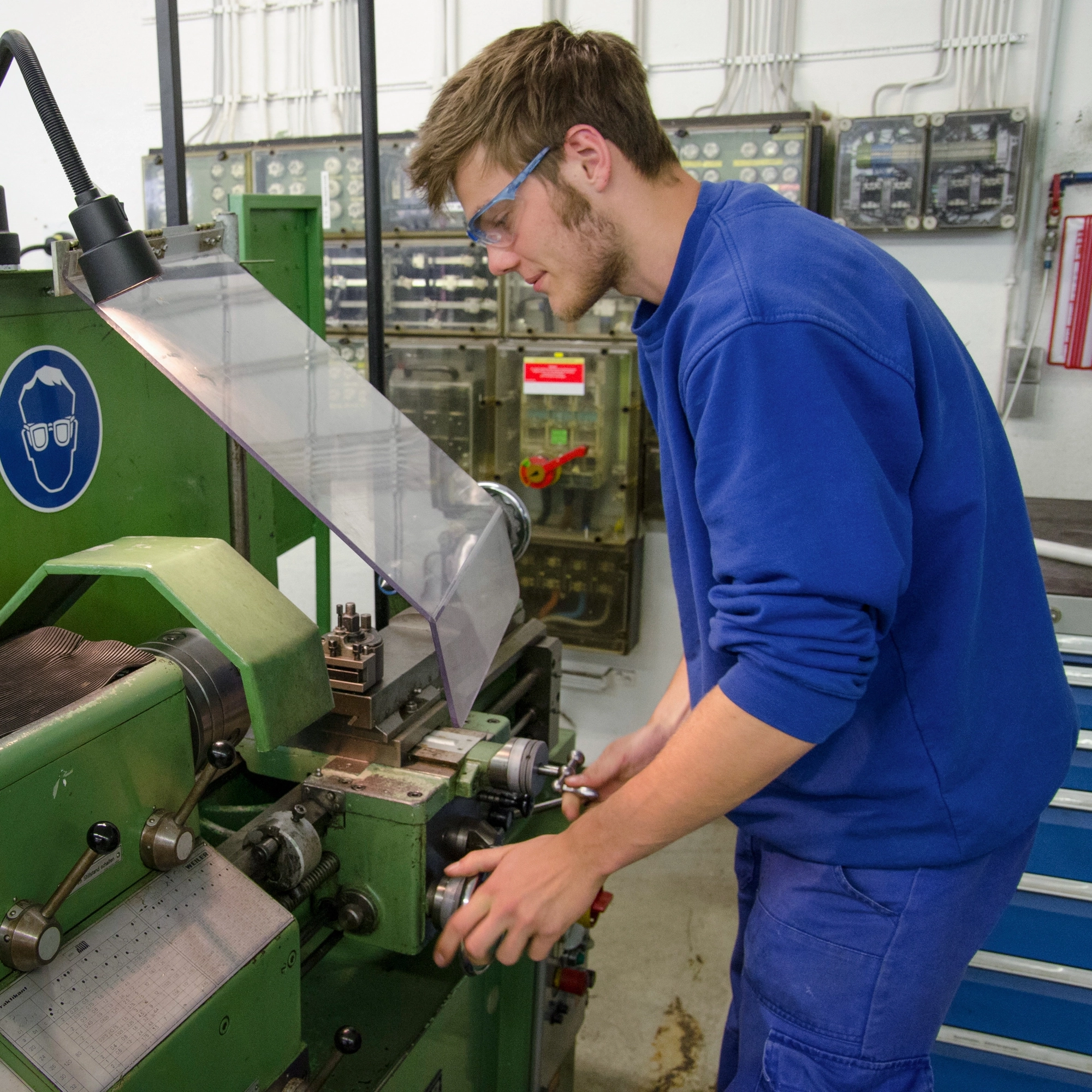 Junger Mann bei der Bedienung einer technischen Maschine