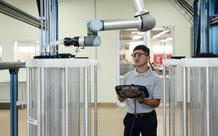 Production worker with a tablet besides a robot