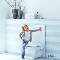 Child leans against a white glass panel above a toilet
