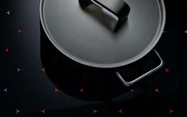 Topf auf einer Kochfläche mit farbigen Lichtelementen 