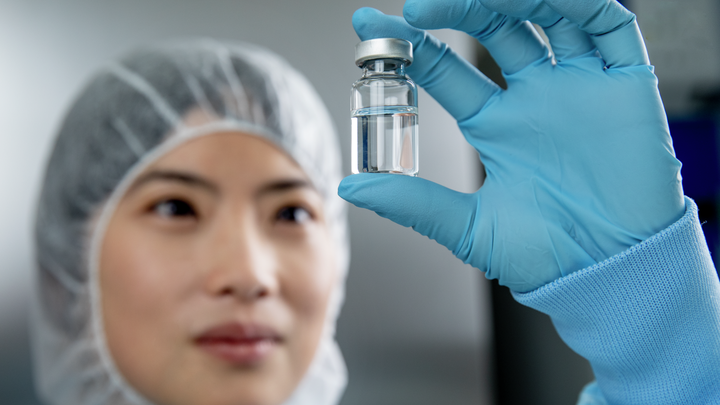 woman looking at glass vial