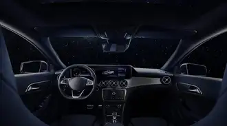 Inside a car, showing a steering wheel and dashboard.