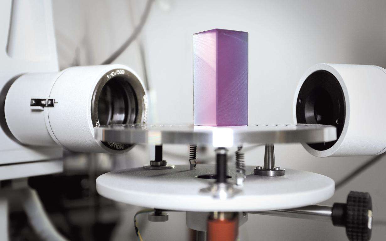 A cuboid of SCHOTT laser glass stands in a laboratory and is optically inspected by cameras.