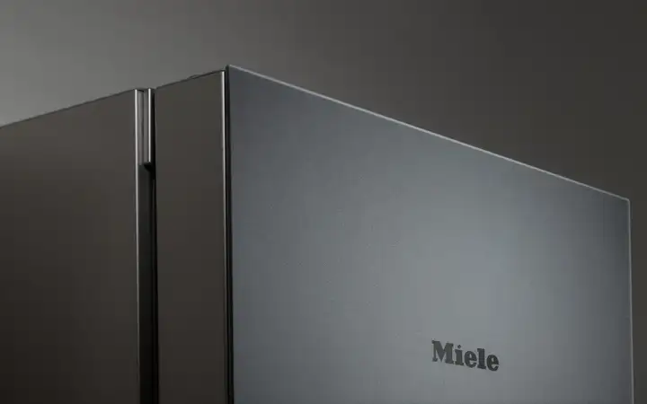 Close up of a Miele refrigerator with matt black glass front