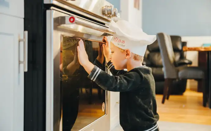 Children are looking in an oven.