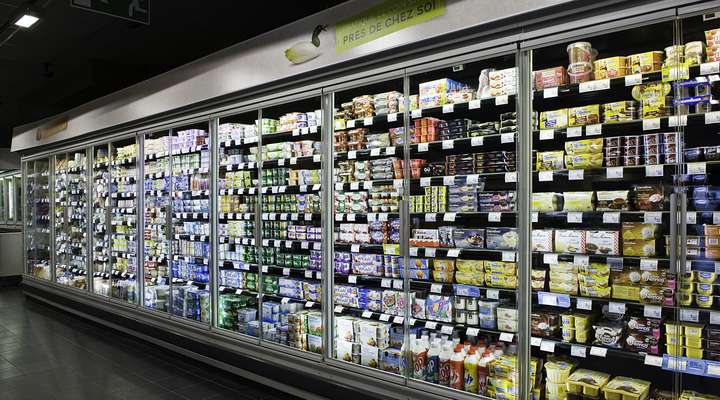Line of refrigerators inside a supermarket with clear glass fronts