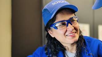 Woman in blue production clothing with safety goggles and protective cap
