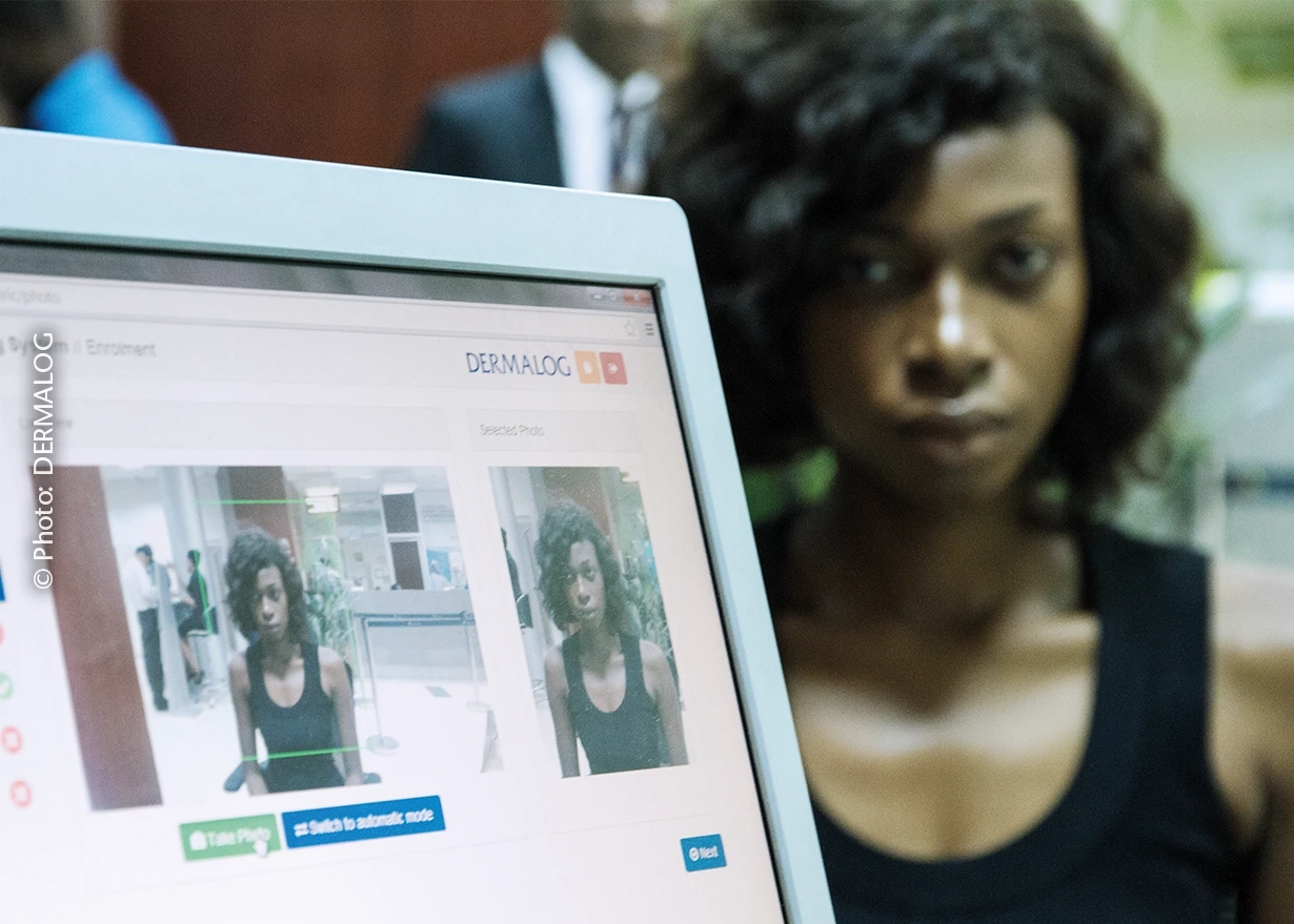 Woman sitting behind computer monitor with facial recognition software