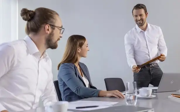 A group of four colleagues in a business environment smiling and giving a high-five