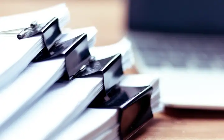 Stack of paper held together with bulldog clips