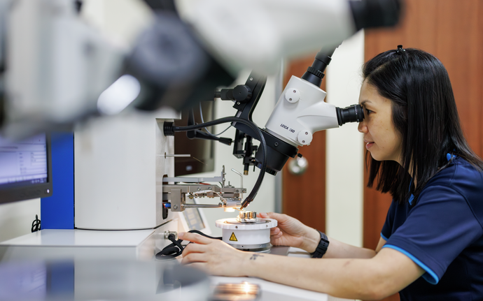 Woman looking through a microscope.