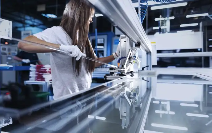 Female SCHOTT employee in the production process of SCHOTT Termofrost® glass doors