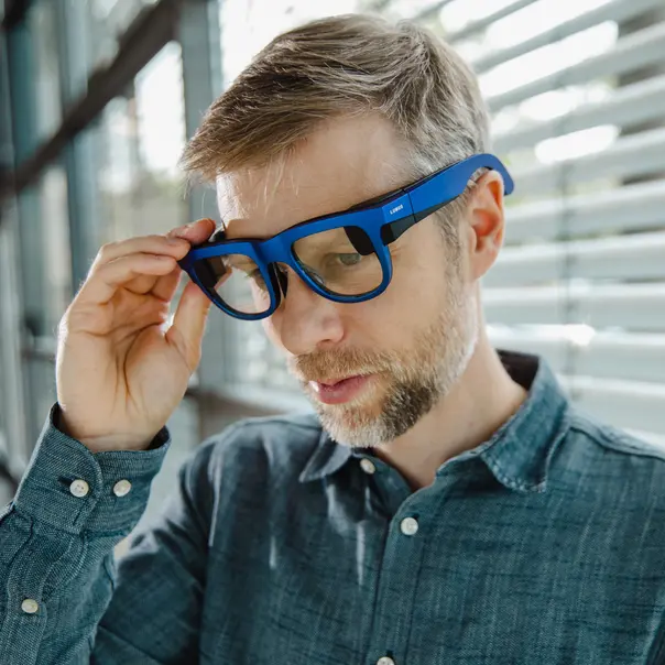 A man wearing augmented reality glasses that look and feel the same as traditional corrective glasses