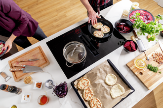 Kitchenette with glass-ceramic cooktop preparing naan bread