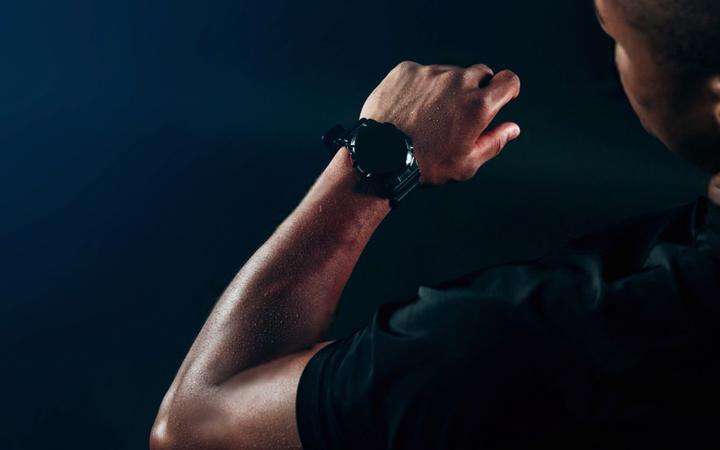 Man looking at his smartwatch in darkness