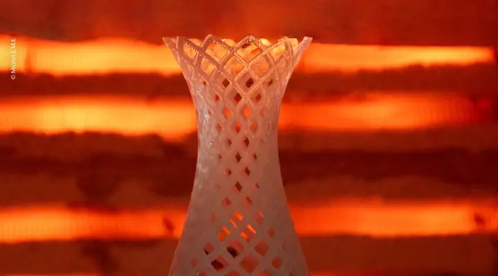 3D printed glass ornament in front of orange furnace