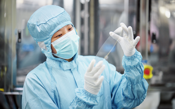 A scientist working in a laboratory looking at mirror discs